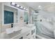 Bathroom with white double sink vanity with a black faucet and a shower at 9027 Merrimoor Blvd, Seminole, FL 33777