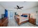 Bedroom with a ceiling fan, hardwood floors, and a bathroom with a shower in background at 9027 Merrimoor Blvd, Seminole, FL 33777