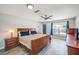 Spacious bedroom featuring hardwood floors, a ceiling fan, and a large window for natural light at 9027 Merrimoor Blvd, Seminole, FL 33777