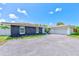 Single-story home featuring a combination of dark stone and white siding, with an attached two-car garage and driveway at 9027 Merrimoor Blvd, Seminole, FL 33777