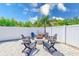 A charming outdoor fire pit setting with Adirondack chairs surrounded by a white privacy fence at 9027 Merrimoor Blvd, Seminole, FL 33777