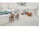 Open-concept living space with modern lighting, tile floors, and an inviting kitchen, great for entertaining at 9027 Merrimoor Blvd, Seminole, FL 33777