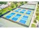 Aerial view of the community's vibrant blue and green pickleball courts, offering residents a fun and active lifestyle at 9027 Merrimoor Blvd, Seminole, FL 33777
