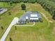 Aerial view of a home on a large lot, featuring a pool, long driveway, and an expansive lawn at 937 Old Welcome Rd, Lithia, FL 33547