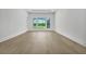 Sun-filled bedroom with tray ceiling, beautiful hardwood floors, and a view of backyard at 937 Old Welcome Rd, Lithia, FL 33547