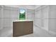 Walk-in closet with custom shelving, an island, marble floors, and a large window at 937 Old Welcome Rd, Lithia, FL 33547