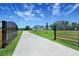 Long private driveway leading to a stylish home, framed by lush green lawns and mature trees at 937 Old Welcome Rd, Lithia, FL 33547