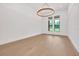 Light-filled living room with hardwood floors, a modern chandelier, and large windows at 937 Old Welcome Rd, Lithia, FL 33547