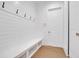 Mud room features white wainscoting, a built-in bench with storage, and a coat rack at 937 Old Welcome Rd, Lithia, FL 33547