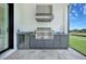 Outdoor kitchen featuring stainless steel grill, granite countertops, and under-counter refrigerator at 937 Old Welcome Rd, Lithia, FL 33547