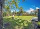 Large backyard with green grass, mature trees, and a wooden fence, offering privacy and space at 1011 Newton S Ave, St Petersburg, FL 33705