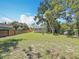 The large backyard has a wooden fence, green grass and a good sized space between the home and the fence at 1011 Newton S Ave, St Petersburg, FL 33705