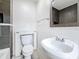 Bright bathroom featuring a white sink, toilet with built-in storage, and modern gray tile accents at 1011 Newton S Ave, St Petersburg, FL 33705