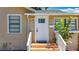 Inviting front entrance with a white door, small porch, and matching white railings at 1011 Newton S Ave, St Petersburg, FL 33705