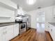 Updated kitchen features stainless steel appliances, white cabinets, and wood-look flooring at 1011 Newton S Ave, St Petersburg, FL 33705