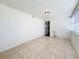 Open living room with tiled floors, light-colored walls, and a doorway to another room with a kitchen view at 1011 Newton S Ave, St Petersburg, FL 33705