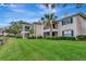 Exterior view of a condo building featuring a well-maintained lawn and screened balconies at 10330 Carrollwood Ln # 95, Tampa, FL 33618