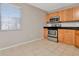 Compact kitchen with wooden cabinets, stainless steel oven and a white tile floor at 10330 Carrollwood Ln # 95, Tampa, FL 33618