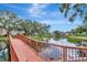Scenic view of a pond with a wooden bridge and lush landscaping with community buildings in background at 10330 Carrollwood Ln # 95, Tampa, FL 33618
