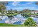 Scenic view of a tranquil pond reflecting the sky, surrounded by lush greenery and condominium buildings at 10330 Carrollwood Ln # 95, Tampa, FL 33618