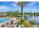 Pool area with chairs and tables overlooking a picturesque pond with fountain and vibrant tropical landscaping at 10330 Carrollwood Ln # 95, Tampa, FL 33618