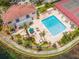 Aerial view of a community pool, showcasing lounge chairs and lush landscaping by the lake at 10330 Carrollwood Ln # 95, Tampa, FL 33618