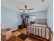 Light blue bedroom with ceiling fan, exercise machine, bed, and a large window allowing for ample natural light at 10502 Lake Williams Dr, Odessa, FL 33556