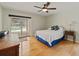 Well-lit bedroom featuring hardwood floors, sliding glass doors leading to the pool, and a ceiling fan at 10502 Lake Williams Dr, Odessa, FL 33556