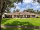 Charming ranch-style home with a lush green lawn, mature trees, and inviting curb appeal at 10502 Lake Williams Dr, Odessa, FL 33556