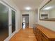 Inviting hallway with gleaming hardwood floors, decorative mirror, and bright, open doorways at 10502 Lake Williams Dr, Odessa, FL 33556