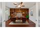 Inviting home office with custom wood bookshelves, a ceiling fan, and a neutral area rug at 10502 Lake Williams Dr, Odessa, FL 33556