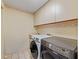Bright laundry room with tiled flooring and upper cabinets, featuring a side-by-side washer and dryer at 10502 Lake Williams Dr, Odessa, FL 33556