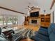 Cozy living room with a brick fireplace, built-in shelves, and sliding doors to the pool area at 10502 Lake Williams Dr, Odessa, FL 33556