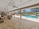 Expansive outdoor pool area with hot tub, outdoor kitchen, bar, seating and travertine floors inside a screened enclosure at 10502 Lake Williams Dr, Odessa, FL 33556