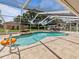 Enjoy this refreshing pool and backyard featuring rock waterfall feature in a screened in lanai with travertine tile at 10502 Lake Williams Dr, Odessa, FL 33556