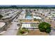 This aerial view showcases the community's pool, shuffleboard courts, canal access, and neatly arranged mobile homes under sunny skies at 108 W Saint Annes Cir, Apollo Beach, FL 33572
