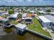 Aerial view of waterfront home with boat lift and lush landscaping in a vibrant community at 108 W Saint Annes Cir, Apollo Beach, FL 33572