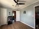 Cozy bedroom with laminate floors, ceiling fan, and neutral paint, next to bathroom at 108 W Saint Annes Cir, Apollo Beach, FL 33572