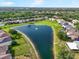 Aerial view of a serene pond surrounded by lush greenery and well-spaced homes at 11132 Creek Haven Dr, Riverview, FL 33569
