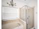 Bright main bathroom with a tub, glass shower, and window for natural light at 11132 Creek Haven Dr, Riverview, FL 33569