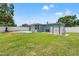 Home's backyard features a new white fence, tropical trees and a convenient storage shed at 11829 104Th St, Largo, FL 33773