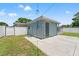 Exterior rear view featuring the home's storage building, backyard, and gated privacy fence at 11829 104Th St, Largo, FL 33773
