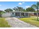 Inviting exterior view of the home with screen room and driveway at 11829 104Th St, Largo, FL 33773
