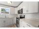 Bright kitchen featuring white cabinets, gray countertops, stainless appliances, and a window with natural light at 11829 104Th St, Largo, FL 33773