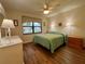 Cozy bedroom with wood-look floors, ceiling fan, and bright window at 1286 Mission Hills Blvd, Clearwater, FL 33759
