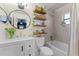 Modern bathroom featuring a vanity, a round mirror, decorative shelves, and a shower/tub combo at 1313 W Carissa Ct, Tampa, FL 33604