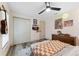 Comfortable bedroom showcasing a warm checkered blanket, overhead fan, and wood-look flooring at 1313 W Carissa Ct, Tampa, FL 33604
