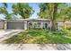Charming single-story home featuring a well-manicured lawn and a two-car garage at 1313 W Carissa Ct, Tampa, FL 33604