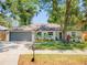 Inviting single-story home with a landscaped front yard and a gray two-car garage at 1313 W Carissa Ct, Tampa, FL 33604