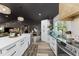 Spacious kitchen featuring white cabinetry, stainless appliances, an island, and dark countertops at 1313 W Carissa Ct, Tampa, FL 33604